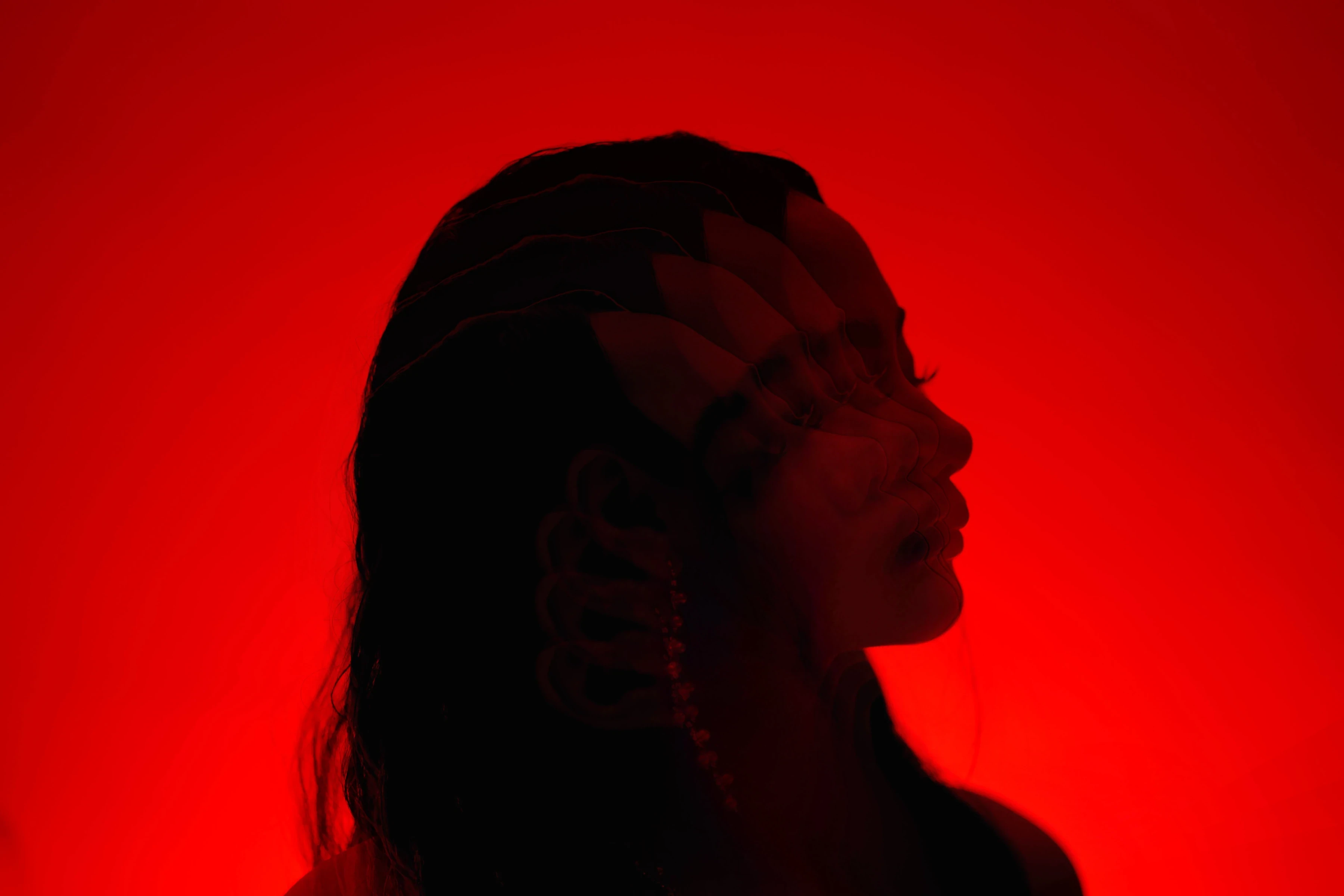 A red-lit portrait in silhouette